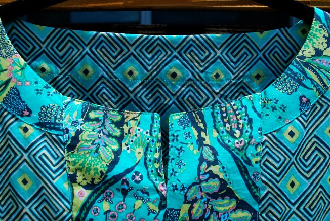 The neck trim is attached by sewing right and wrong side together at the neck edge so the seam allowances are tucked inside, and there is no need for a facing.